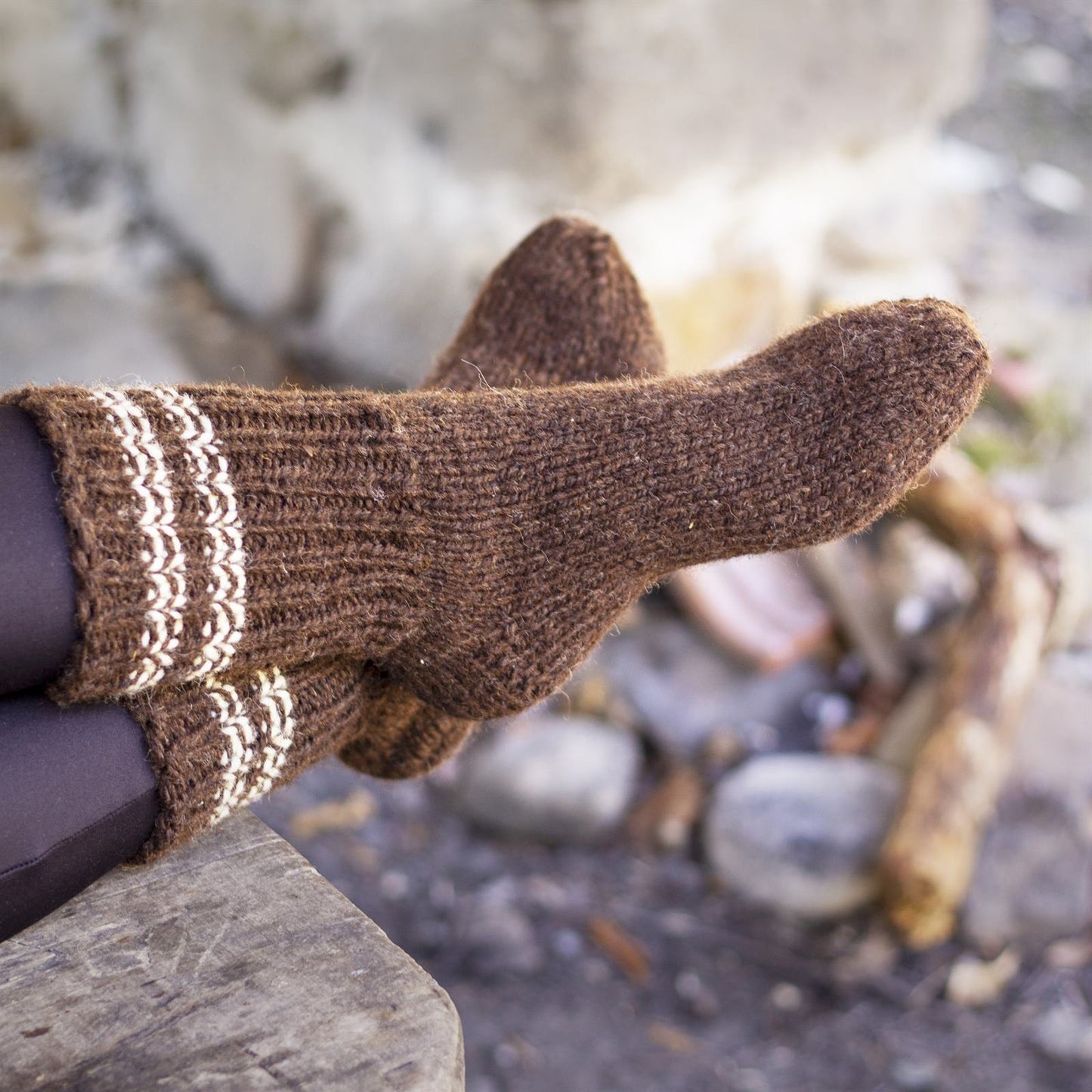 Close-up of handmade thick winter 100% sheep wool socks in brown, held outdoors, from Bulgaria