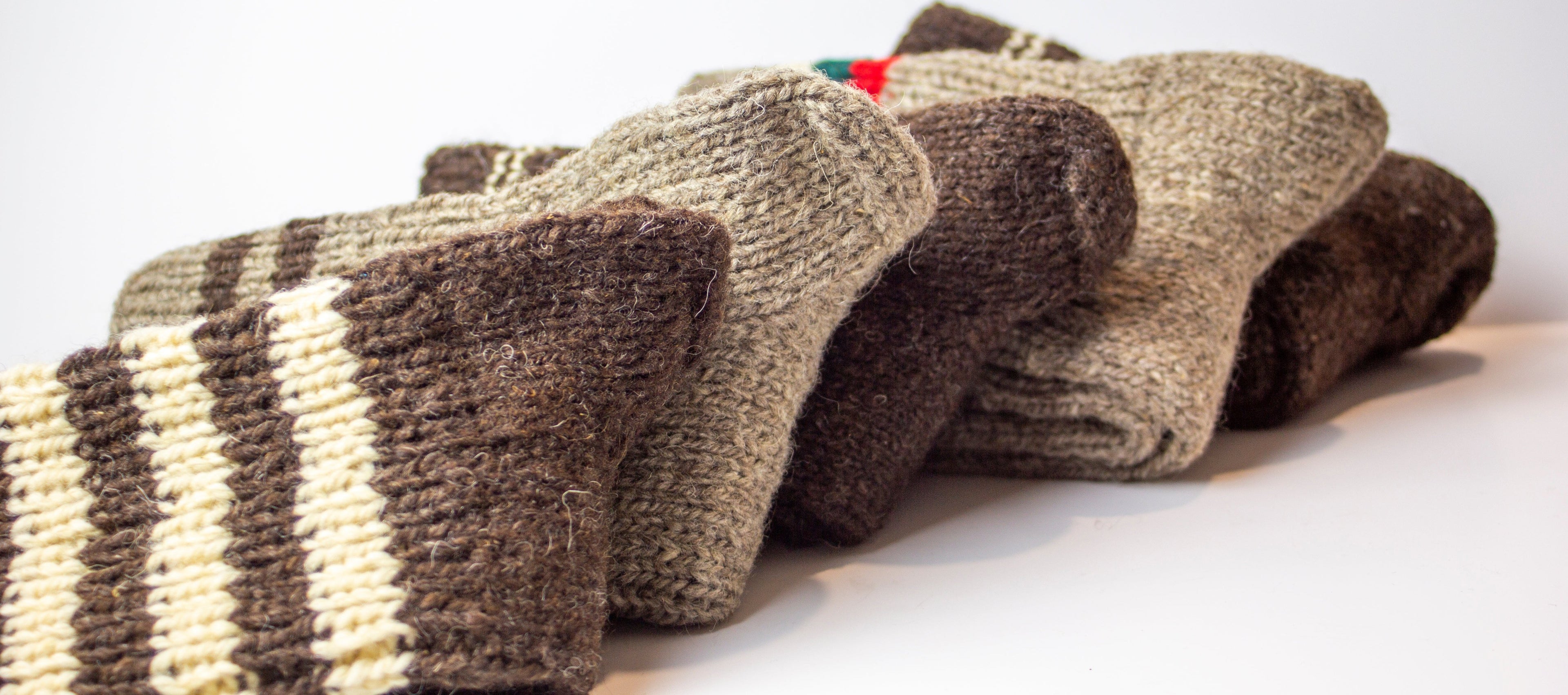 A bundle of handknitted thick wool socks in natural colors